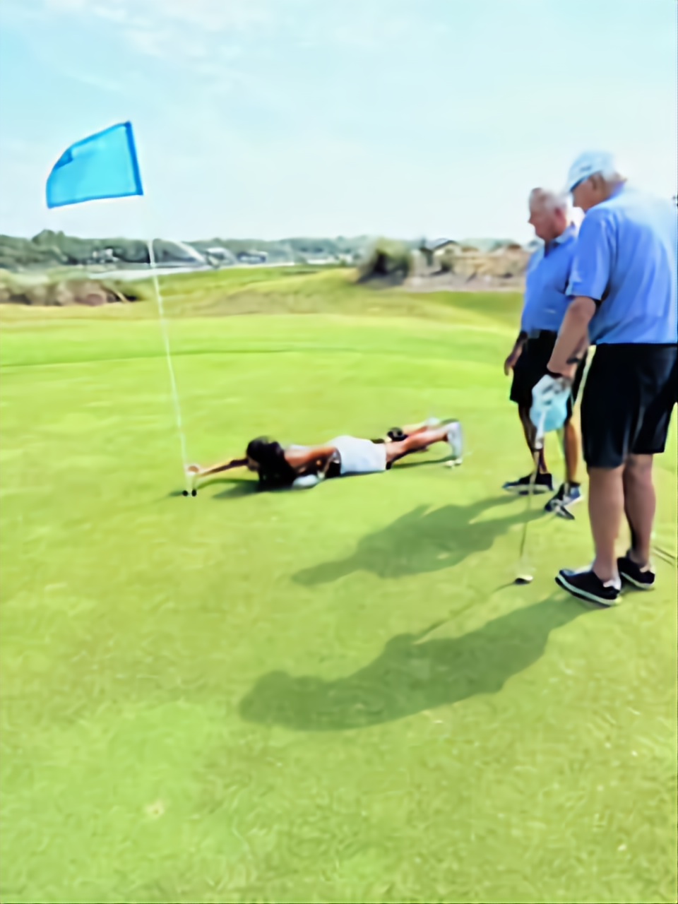 Wild Dunes member lying flat on the green reading a putt